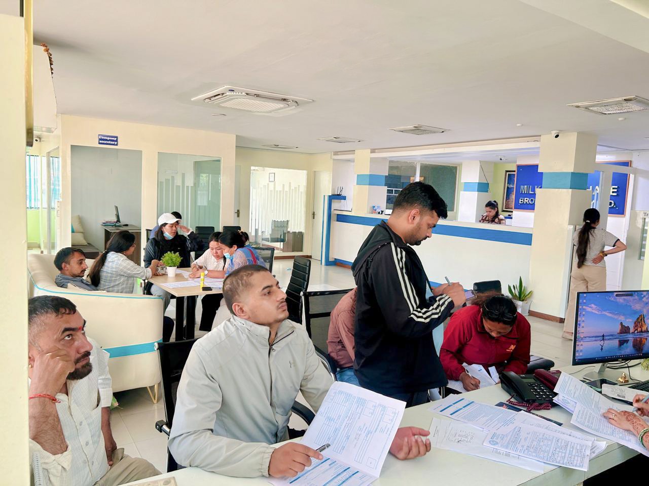 Clients completing account forms at the Milky Way office